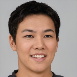 Joyful asian young-adult male with short  brown hair and brown eyes