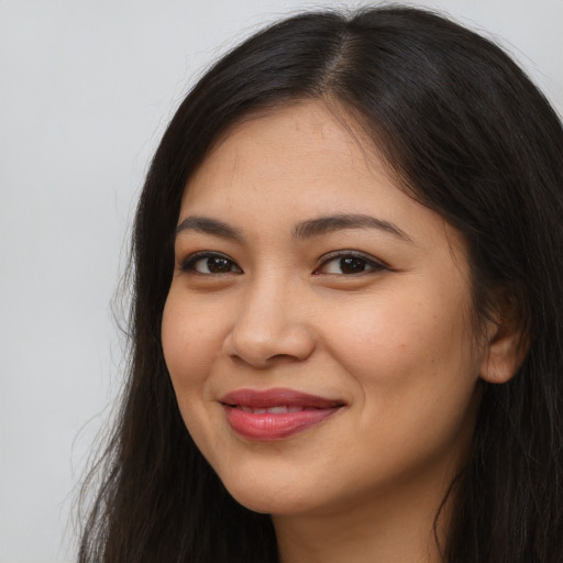 Joyful latino young-adult female with long  brown hair and brown eyes