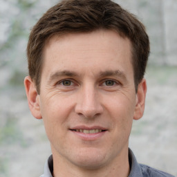 Joyful white young-adult male with short  brown hair and grey eyes