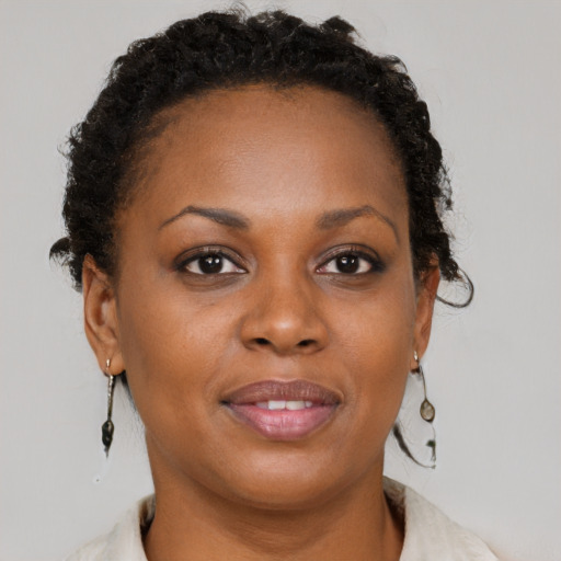 Joyful black young-adult female with short  brown hair and brown eyes