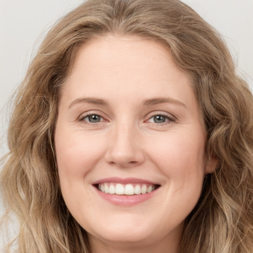 Joyful white young-adult female with long  brown hair and green eyes