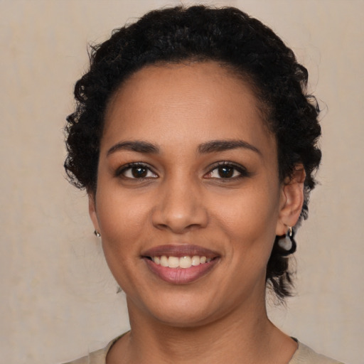Joyful latino young-adult female with short  black hair and brown eyes