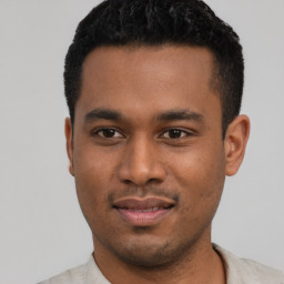 Joyful latino young-adult male with short  black hair and brown eyes