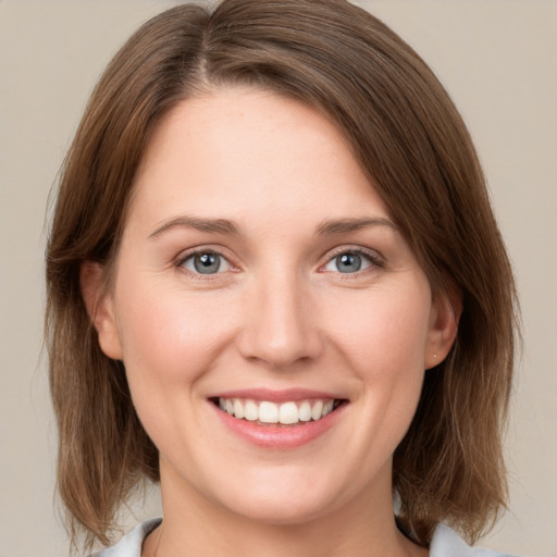 Joyful white young-adult female with medium  brown hair and grey eyes