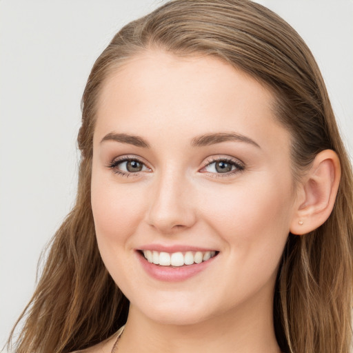 Joyful white young-adult female with long  brown hair and blue eyes