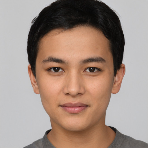 Joyful asian young-adult male with short  black hair and brown eyes