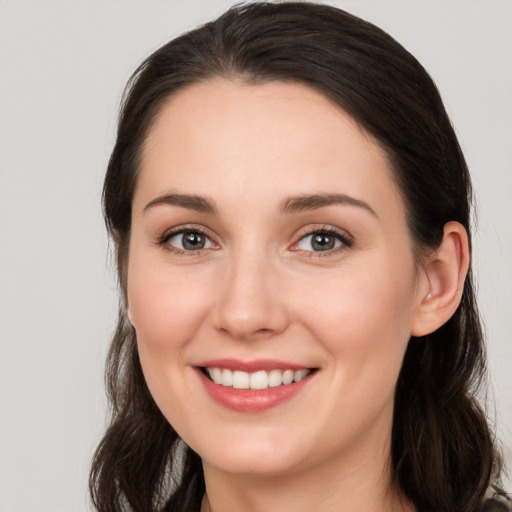 Joyful white young-adult female with long  brown hair and brown eyes