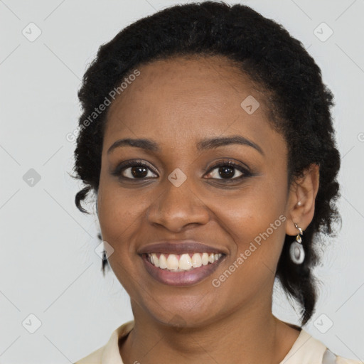 Joyful black young-adult female with long  brown hair and brown eyes