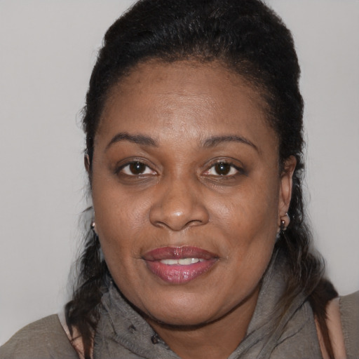 Joyful black adult female with long  brown hair and brown eyes