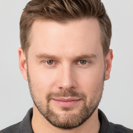 Joyful white young-adult male with short  brown hair and grey eyes