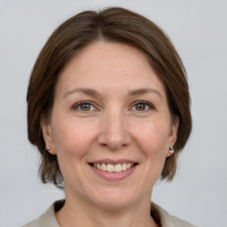 Joyful white adult female with medium  brown hair and grey eyes