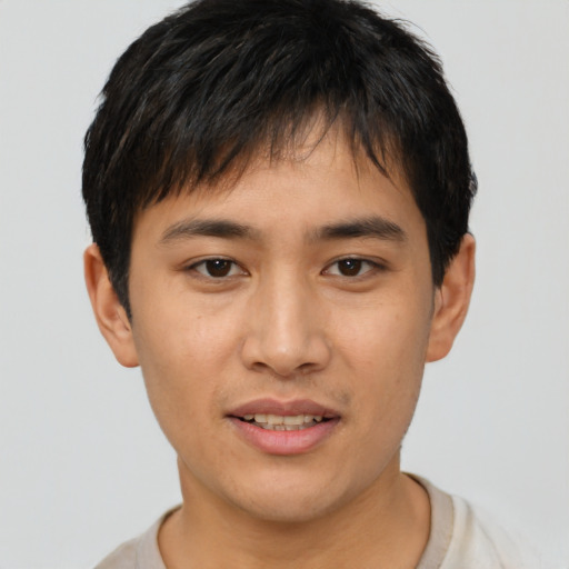 Joyful asian young-adult male with short  black hair and brown eyes