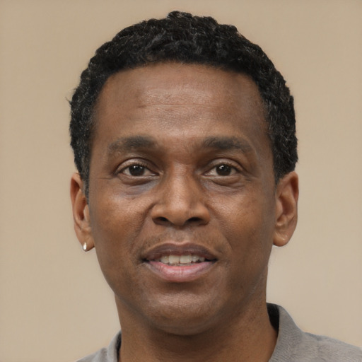 Joyful black adult male with short  black hair and brown eyes