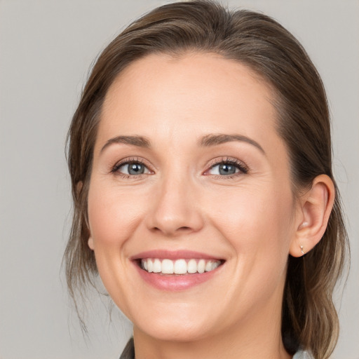 Joyful white young-adult female with medium  brown hair and grey eyes