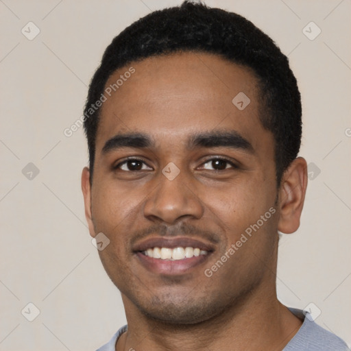 Joyful black young-adult male with short  black hair and brown eyes