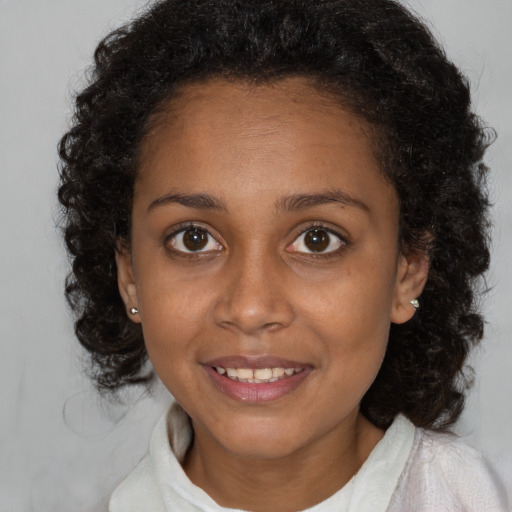 Joyful black young-adult female with medium  brown hair and brown eyes