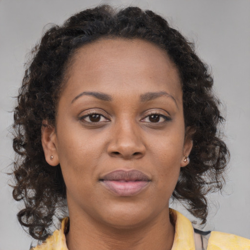 Joyful black adult female with medium  brown hair and brown eyes