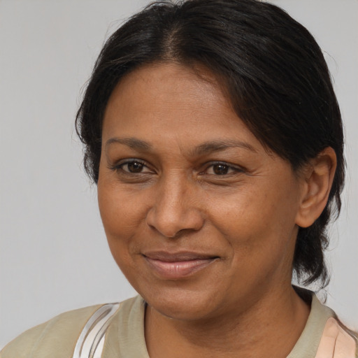 Joyful latino adult female with medium  brown hair and brown eyes