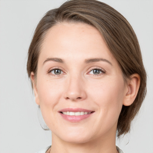 Joyful white young-adult female with medium  brown hair and grey eyes