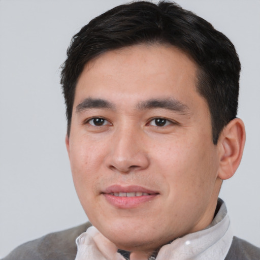 Joyful asian young-adult male with short  brown hair and brown eyes