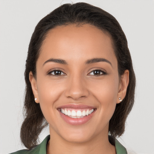 Joyful latino young-adult female with long  brown hair and brown eyes