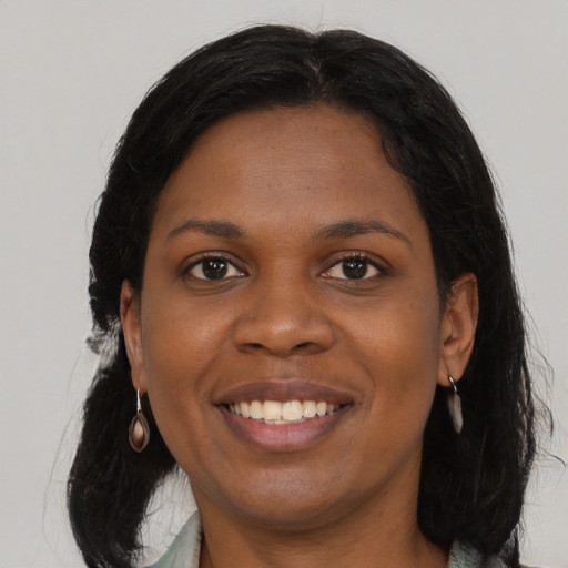Joyful black young-adult female with long  black hair and brown eyes