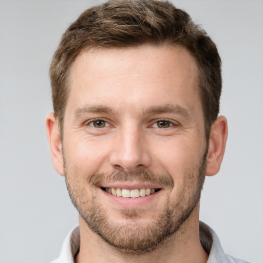 Joyful white young-adult male with short  brown hair and grey eyes