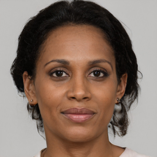 Joyful black adult female with medium  brown hair and brown eyes