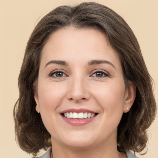 Joyful white young-adult female with medium  brown hair and grey eyes