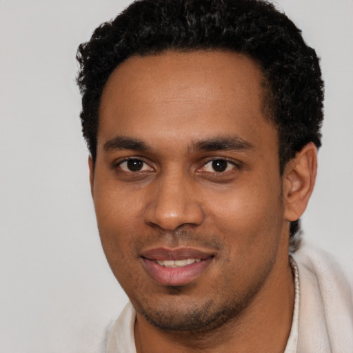 Joyful black young-adult male with short  black hair and brown eyes