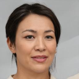 Joyful asian adult female with medium  brown hair and brown eyes