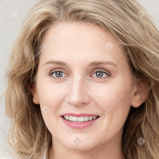 Joyful white young-adult female with long  brown hair and blue eyes