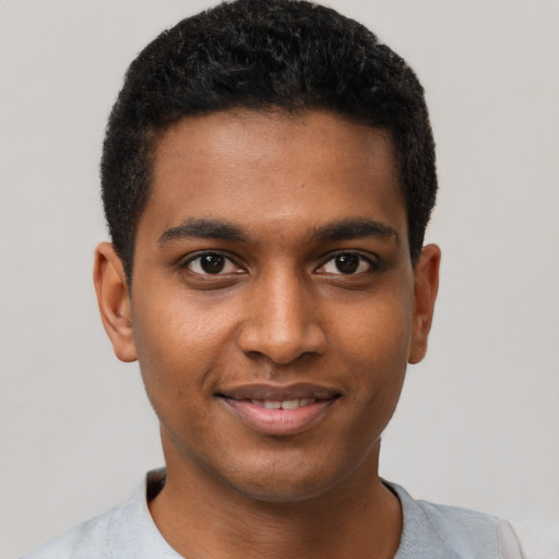 Joyful black young-adult male with short  black hair and brown eyes