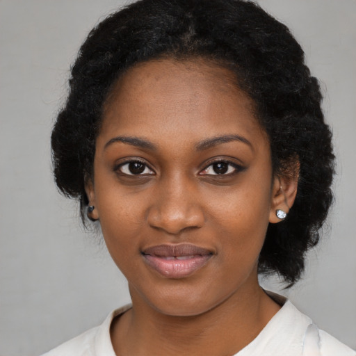 Joyful black young-adult female with medium  black hair and brown eyes