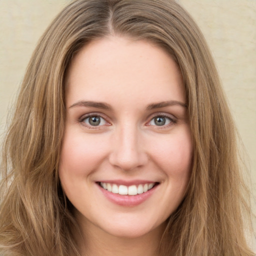 Joyful white young-adult female with long  brown hair and green eyes