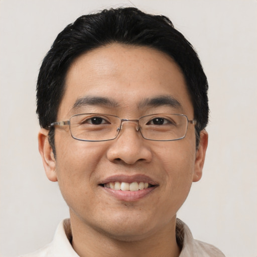 Joyful asian adult male with short  black hair and brown eyes