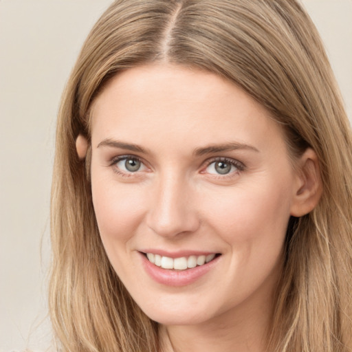 Joyful white young-adult female with long  brown hair and green eyes