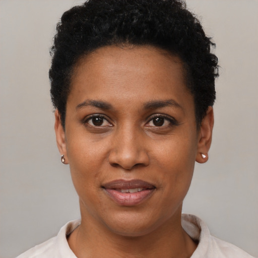 Joyful black young-adult female with short  black hair and brown eyes