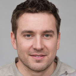 Joyful white young-adult male with short  brown hair and grey eyes