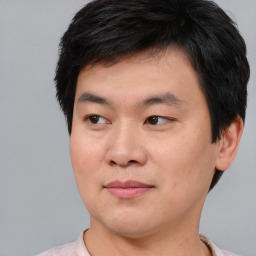 Joyful asian young-adult male with short  brown hair and brown eyes