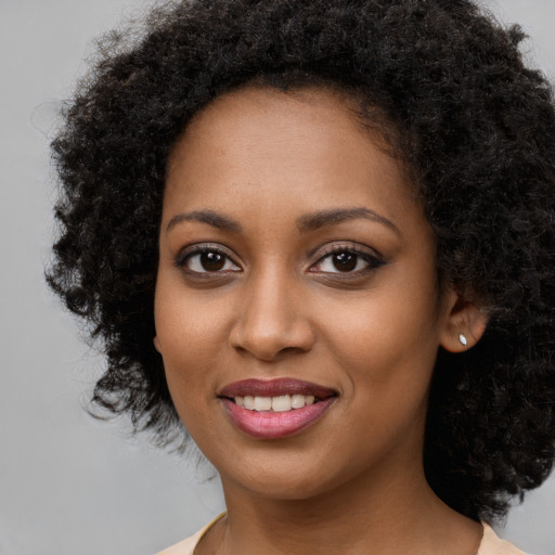 Joyful black young-adult female with long  brown hair and brown eyes