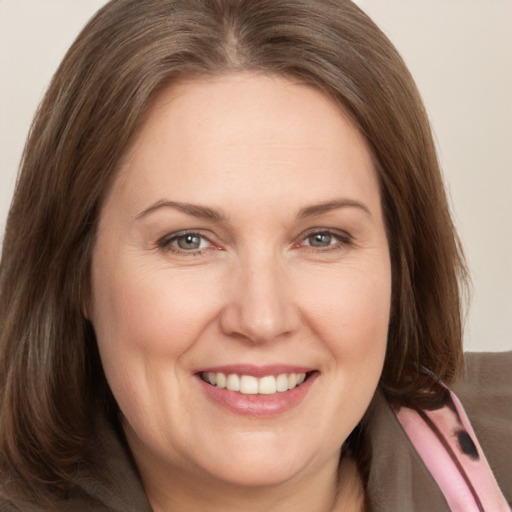 Joyful white adult female with medium  brown hair and brown eyes