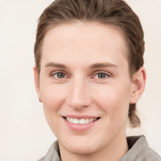 Joyful white young-adult female with short  brown hair and grey eyes