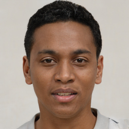 Joyful black young-adult male with short  black hair and brown eyes
