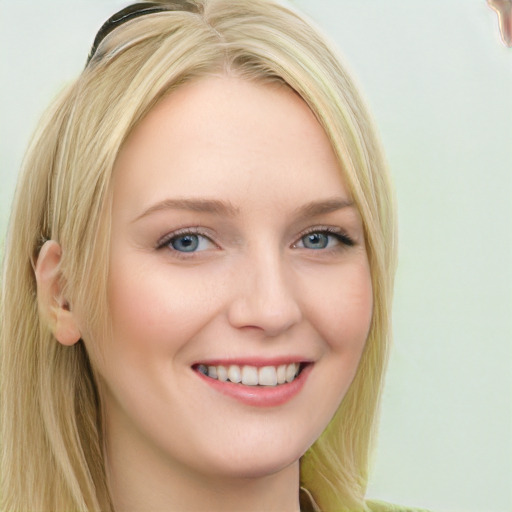 Joyful white young-adult female with long  blond hair and blue eyes