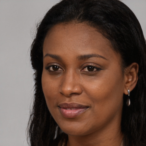 Joyful black young-adult female with long  brown hair and brown eyes