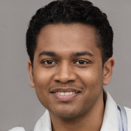 Joyful latino young-adult male with short  black hair and brown eyes