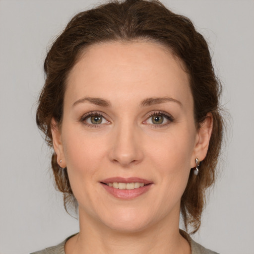 Joyful white young-adult female with medium  brown hair and green eyes