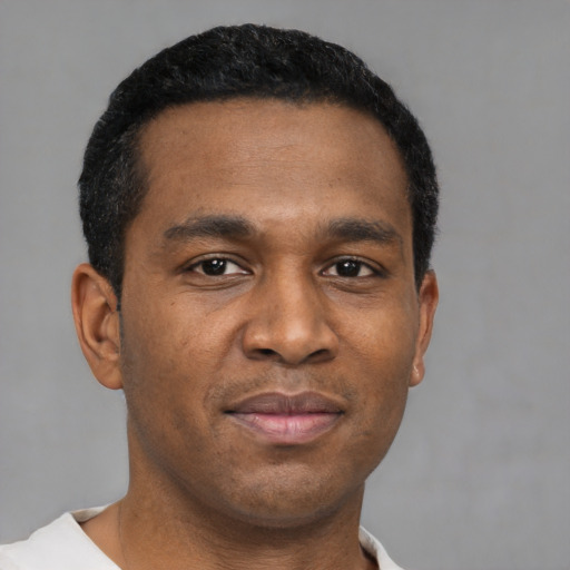 Joyful black young-adult male with short  black hair and brown eyes
