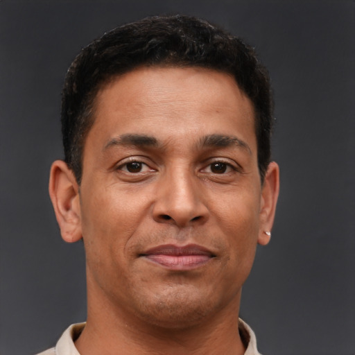 Joyful latino adult male with short  brown hair and brown eyes